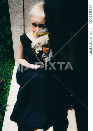 A woman sitting by the window with dried flowers A woman sitting by the window with dried flowers 106159133