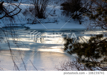 View of the winter river with melting ice at the end of winter View of the winter river with melting ice at the end of winter 106159741