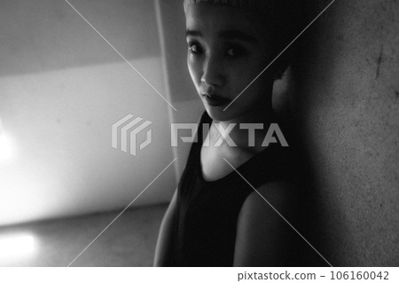 Black and white photo of a young woman standing indoors Black and white photo of a young woman standing indoors 106160042