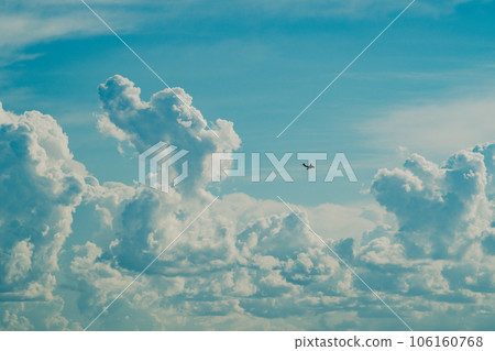 Cumulonimbus clouds rising in the summer sky and airplanes flying around a-5 film style 106160768