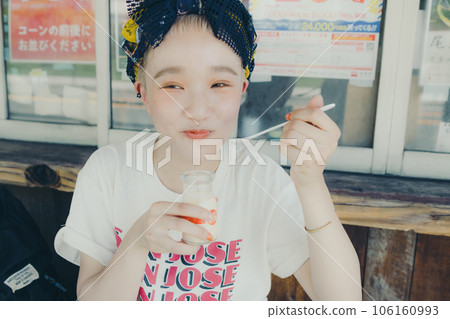A woman eating pudding at a tourist spot 106160993