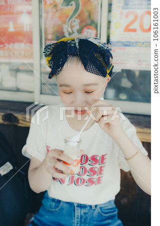 A woman eating pudding at a tourist spot A woman eating pudding at a tourist spot 106161003