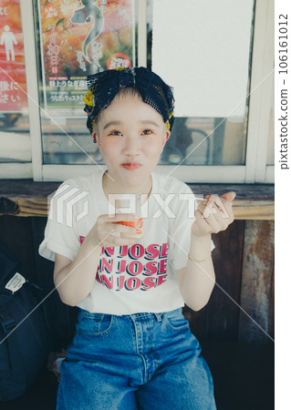 A woman eating pudding at a tourist spot 106161012