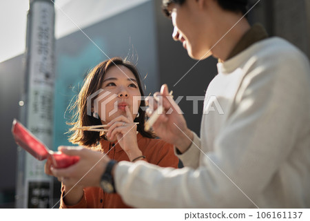 微笑的情侶邊走邊吃 106161137