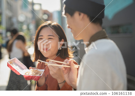 微笑的情侶邊走邊吃 106161138