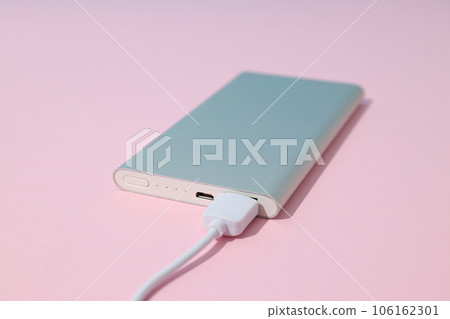 Powerbank and cord on pink background, close up Powerbank and cord on pink background, close up 106162301