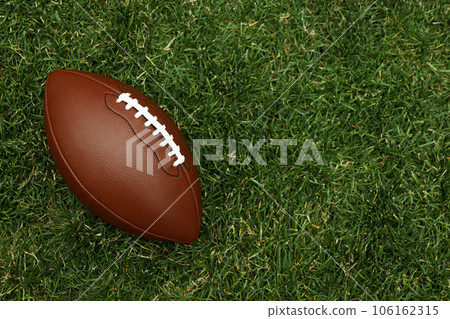 American football ball on green grass background 106162315