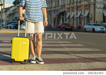 Woman with yellow suitcase on road in the city, space for text 106162403