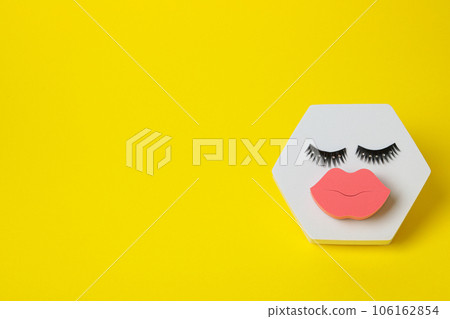 Cosmetic sponge and false eyelashes on yellow background, space for text Cosmetic sponge and false eyelashes on yellow background, space for text 106162854