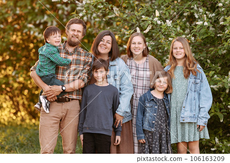 Large friendly family in the summer on the field. 106163209