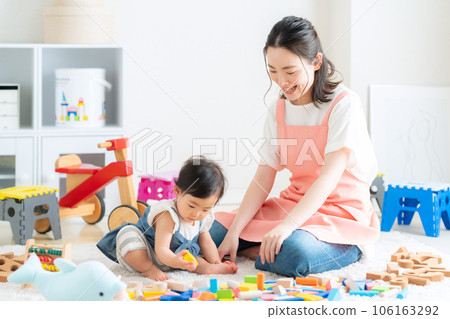 Young nursery teacher playing with baby in nursery 106163292