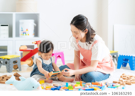 Young nursery teacher playing with baby in nursery 106163293