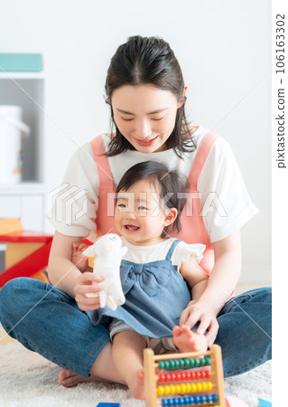 Young nursery teacher playing with baby in nursery 106163302