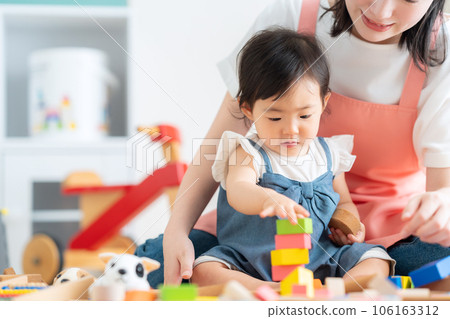 年輕的托兒所老師在托兒所和嬰兒玩耍 106163312
