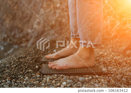 Sea Woman feet stepping on sadhu board during indian practice on the seashore. . Healthy lifestyle concept. tool for working out your inner state 106163412