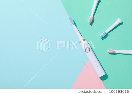 Electric toothbrushes on blue and green background, space for text 106163616