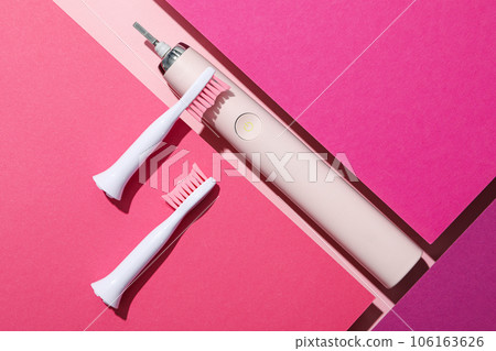 Electric toothbrush on pink background, top view Electric toothbrush on pink background, top view 106163626