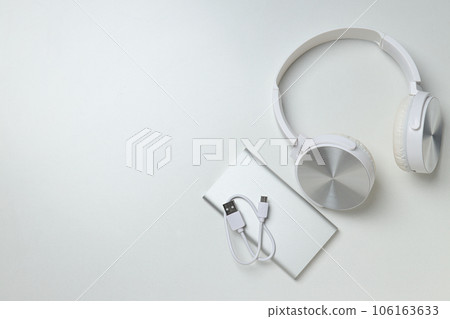 Powerbank, headphones and cord on white background, space for text Powerbank, headphones and cord on white background, space for text 106163633