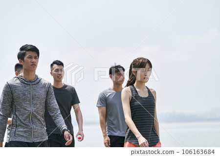group of five young asian adults taking a walking outdoors after exercising 106163684
