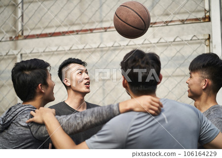 young asian adult men having fun playing with basketball outdoors young asian adult men having fun playing with basketball outdoors 106164229