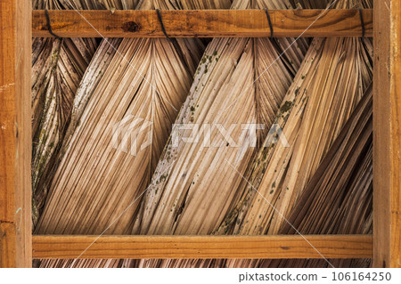 Roofing made of dry palm leaves on wooden frame 106164250
