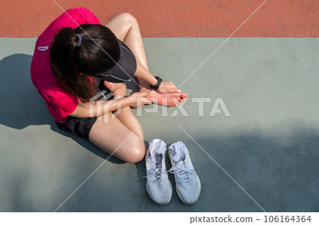 Top view of runner woman suffering from injury and she trying to do foot massage by herself. A foot massage used to decrease pain, relieve tension and improve circulation. Top view of runner woman suffering from injury and she trying to do foot massage by herself. A foot massage used to decrease pain, relieve tension and improve circulation. 106164364