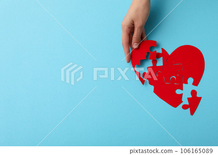 Red heart from puzzles on a blue background. Blood donation, place for text 106165089