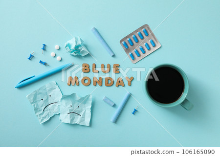 Blue Monday text, pills, cup and stationery on blue background, top view 106165090