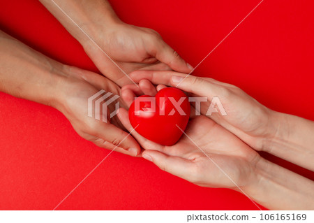 Red heart in arms on a red background. Blood donation 106165169