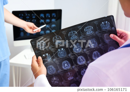 Doctors look at MRI images of a human head Doctors look at MRI images of a human head 106165171