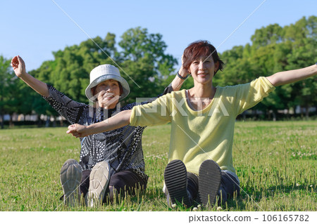 Parents of senior women. sit in nature and stretch together 106165782