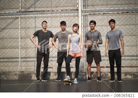 hipster young asian woman posing outdoors with skateboard and four male friends 106165821