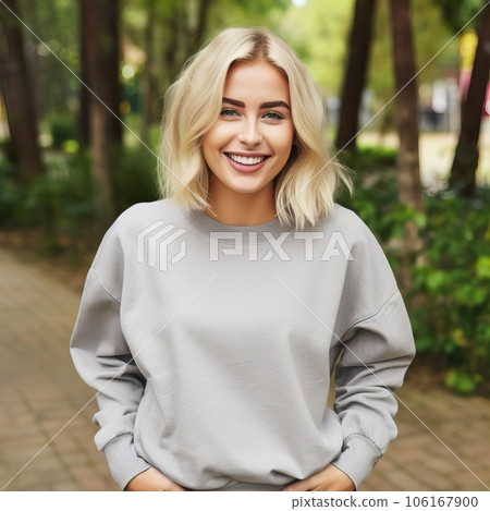 Beautiful young lady dressed in gray sweater, commercial sweatshirt mock-up, smiling blonde woman standing in the street 106167900