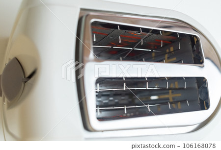 Hot toaster. Top view of an electric appliance for frying bread. Close-up of heating elements and slices of toast bread. Incandescent filaments Hot toaster. Top view of an electric appliance for frying bread. Close-up of heating elements and slices of toast bread. Incandescent filaments 106168078