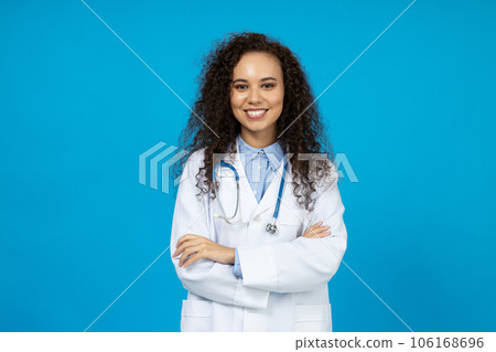 An attractive young girl in a white doctor's uniform on a blue background 106168696