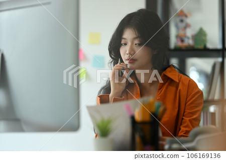 Image of charming young startup businesswoman working on new project at creative workplace 106169136