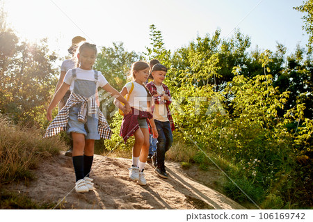 Little boys and girls, children having fun outdoors in forest, going hiking together, enjoying active weekends Little boys and girls, children having fun outdoors in forest, going hiking together, enjoying active weekends 106169742