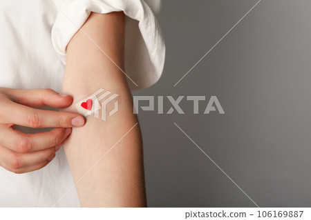 Blood donation. Blood donor with bandage and red heart after donating blood, place for text 106169887