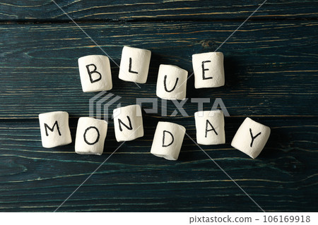 Marshmallows with text Blue Monday on dark blue wooden background, top view 106169918
