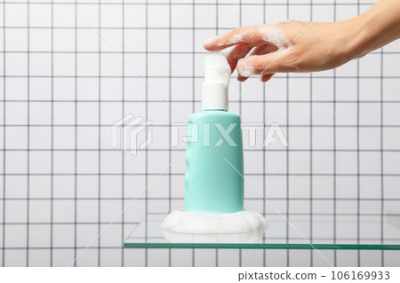 A bottle with a care product in foam. A bottle with a care product in foam. 106169933
