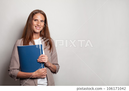 Attractive clever successful business woman with blue folder on white wall banner background 106171042