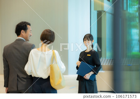 接待處的一位女士正在引導中間夫婦 接待處的一位女士正在引導中間夫婦 106171573