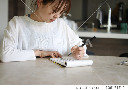A woman writing with a brush pen 106171741