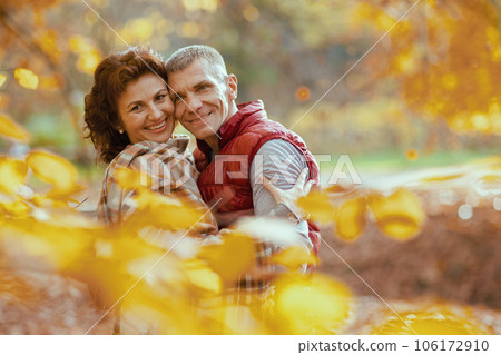 Portrait of smiling modern couple in park embracing 106172910