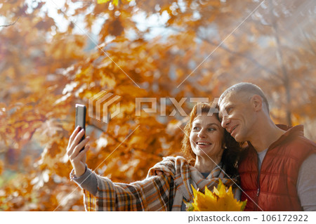 smiling romantic couple in park taking selfie smiling romantic couple in park taking selfie 106172922