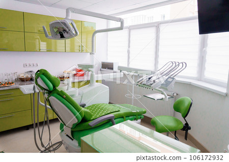 Modern dental office in green. Dental unit with dental instruments. Autoclave 106172932