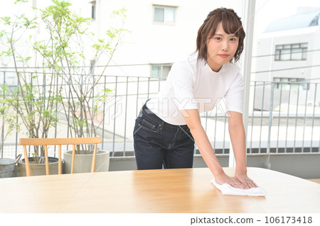 A woman wiping the table with a cloth A woman wiping the table with a cloth 106173418