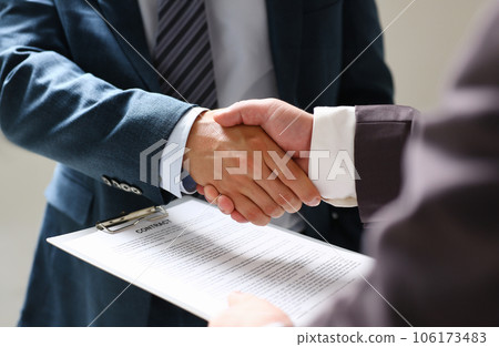 Man in suit shake hand as hello in office closeup Man in suit shake hand as hello in office closeup 106173483