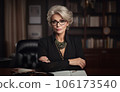 Aged business woman in black suit ceo in office arms crossed portrait. Created with AI 106173540