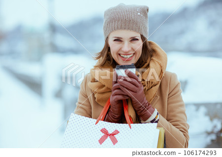 happy elegant woman in brown hat and scarf in camel coat happy elegant woman in brown hat and scarf in camel coat 106174293